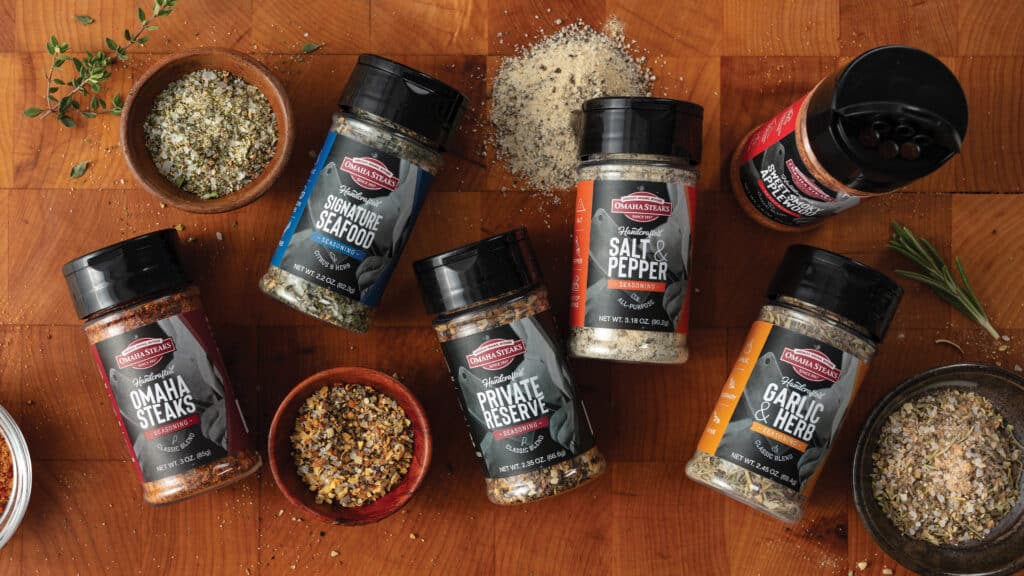 Bottles and bowls of Omaha Steaks seasonings on a cutting board