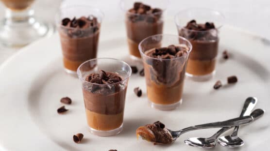 5 mini chocolate caramel mousse cups on a plate with spoons