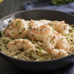 shrimp scampi served in a dish over pasta