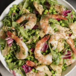 shrimp with asparagus, artichoke and baby peas served over salad greens