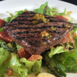 salad with grilled flat iron on white plate