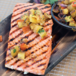 Wild salmon filets grilled and plated with pineapple salsa
