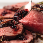red cranberry sauce spooned over cooked chateaubriand roast