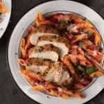 Bowl with penne rigate and sliced Italian chicken