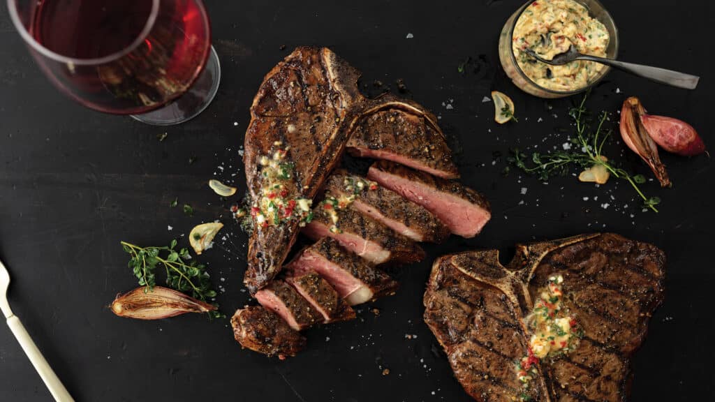 Porterhouse steak sliced sprinkled with maytag blue cheese and served with sun dried tomato butter and a glass of beer