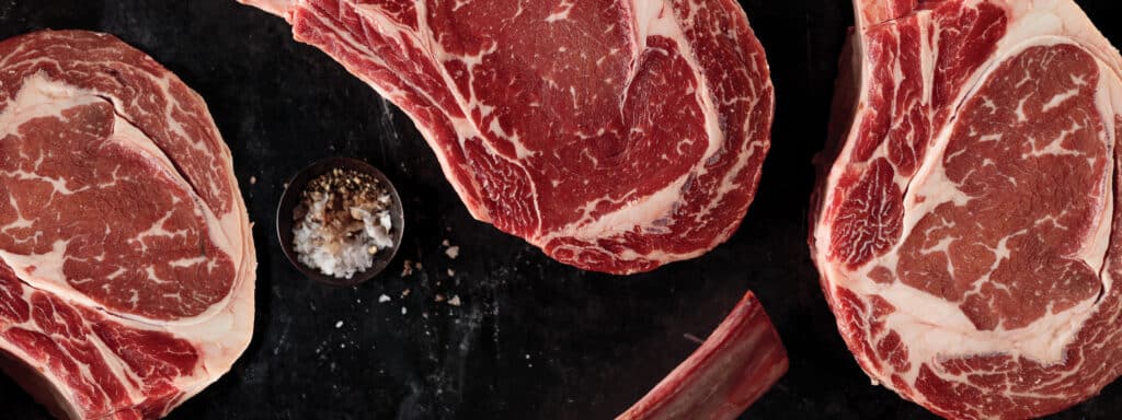 uncooked steak on black countertop