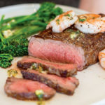 Sear roasted Herb butter New York strip steak with sautéed Wild Argentinian Red Shrimp and spicy buttered broccolini