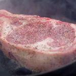 Cooking a dry brined and seasoned tomahawk ribeye steak indoors in a cast iron pan with