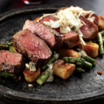 Private reserve new york strip steak oscar style with bernaise sauce and jumbo lump crab meat served with brown butter chive gnocchi with sauteed asparagus