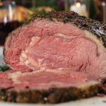 dijon-herb prime rib roast sliced and cooked to medium-rare on a holiday table