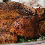 golden brown turkey with crispy skin on a serving platter for Thanksgiving dinner