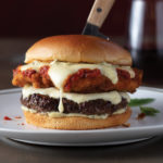 Italian Stallion burger with perfectly seared Omaha Steaks PureGround™ Delmonico Burger, topped with provolone cheese, golden- fried chicken cutlet, spicy marinara sauce, and pesto mayo