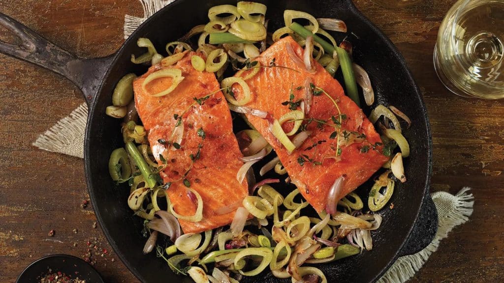 Cast iron pan with 2 pieces wild salmon and sliced green onions