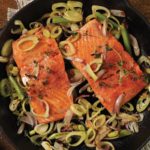 Cast iron pan with 2 pieces wild salmon and sliced green onions