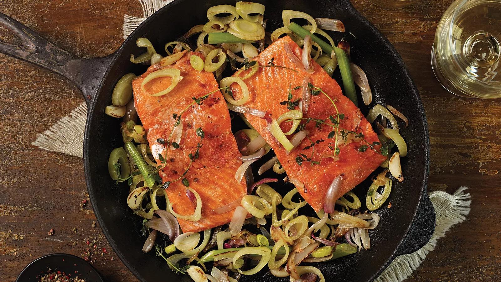 Cast iron pan with 2 pieces wild salmon and sliced green onions