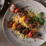 steak kabobs with parmesan orzo on plate