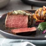 Blue Cheese Chive Butter-Rested Filet Mignon with Fully Loaded Hasselback Potatoes on plate