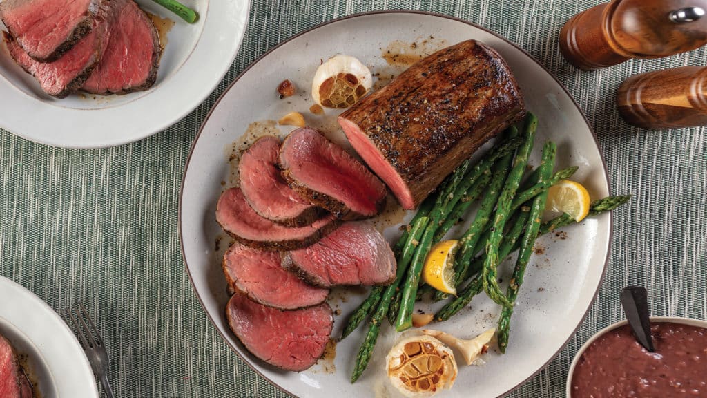 Roasted Chateaubriand with Red Wine Gravy and Lemon-Garlic Asparagus on plate