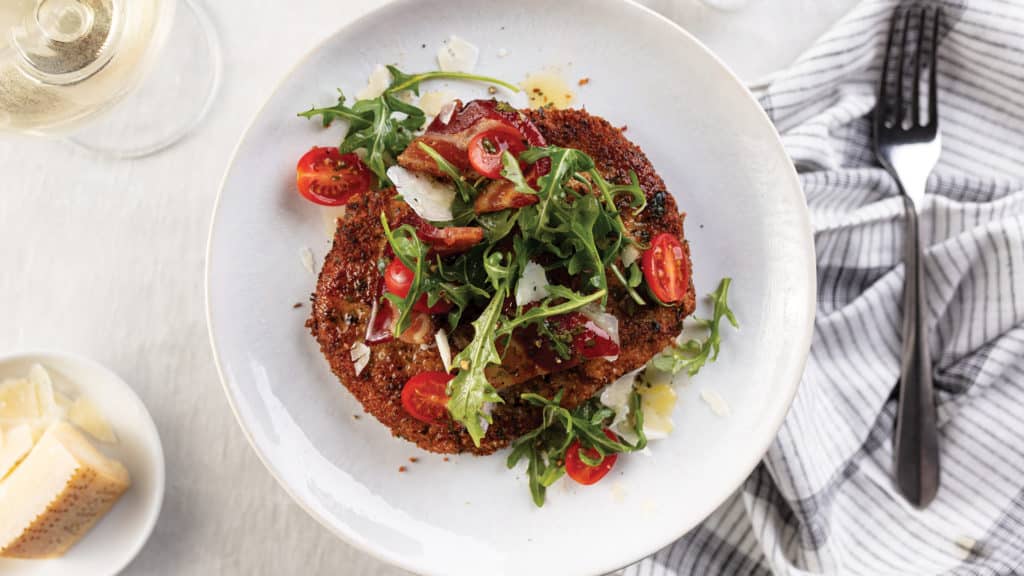 Pork Milanese With Arugula Salad and Warm Bacon Vinaigrette on plate