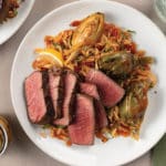 Gilroy Garlic Confit Steaks with Artichoke-Orzo Ragout on plate