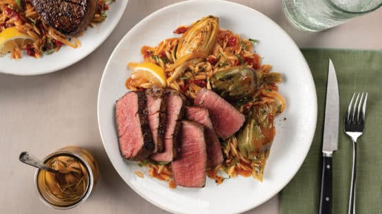 Gilroy Garlic Confit Steaks with Artichoke-Orzo Ragout on plate