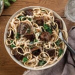 Cheesy pasta with filet mignon tips in a bowl.