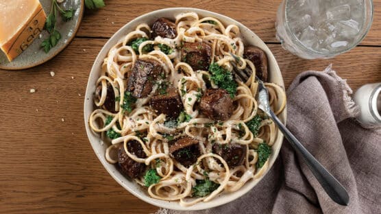 Cheesy pasta with filet mignon tips in a bowl.