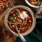 Table set with bowl of chicken and mushroom white bean chili.