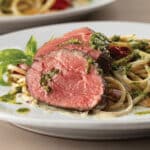 Spinach-Pesto Stuffed Chateaubriand with Broken Spaghetti on a white plate