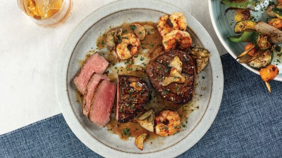 Two Filet Mignon, one sliced and cooked medium-rare served with Whiskey-Glazed Shrimp and Bacon-and-Parmesan au Gratin Potatoes