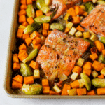 Sheet pan with Omaha Steaks Faroe Island Salmon Fillets, sweet potatoes, Brussels sprouts and fresh herbs.