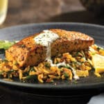 Pan-Seared Marinated Salmon Atop a bed of Sun-Dried Tomato Orzo Pasta and topped with a creamy sauce