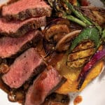 Grilled Bistro Steak sliced into 1/2 inch strips and plated atop Rustic Hash Browns, Grilled Vegetables, and finished with Red Wine & Mushroom Finishing Sauce