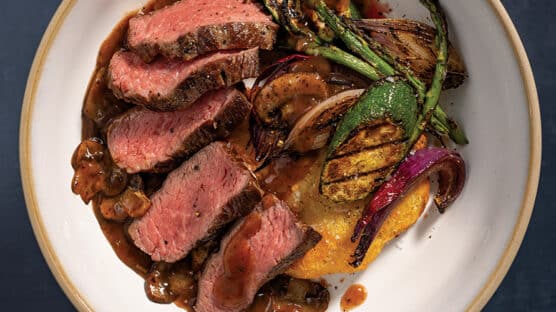 Grilled Bistro Steak sliced into 1/2 inch strips and plated atop Rustic Hash Browns, Grilled Vegetables, and finished with Red Wine & Mushroom Finishing Sauce