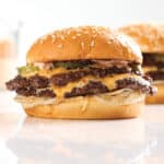 Two Omaha Steaks smash burgers with image of sauce in background