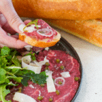 Plate of beef carpaccio and loaf of French Bread