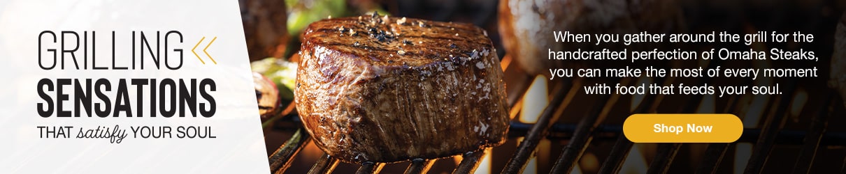 Juicy filet mignon sizzling on a grill with flames and vegetables in the background, promoting Omaha Steaks summer grilling with the tagline “Grilling Sensations That Satisfy Your Soul” and a call-to-action button to shop now.