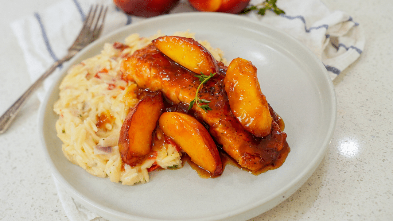 Bourbon peach salmon on a bed of rice on a white plate.