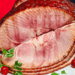 Double Smoked Bourbon and Cherry Glazed Spiral-Sliced Ham on Plate with sliced oranges and cherries