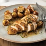 Grey plate with pan-seared chicken and roasted potatoes with pan sauce