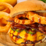 Platter with double smash burger with American cheese, Jalapeños, sliced bacon, cooked onion rings and coated in cowboy butter. Served with a side of onion rings