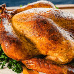 Golden-brown smoked turkey on a white platter