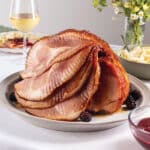 Elegant table with a blackberry bourbon glazed spiral sliced ham and apple-fennel slaw.